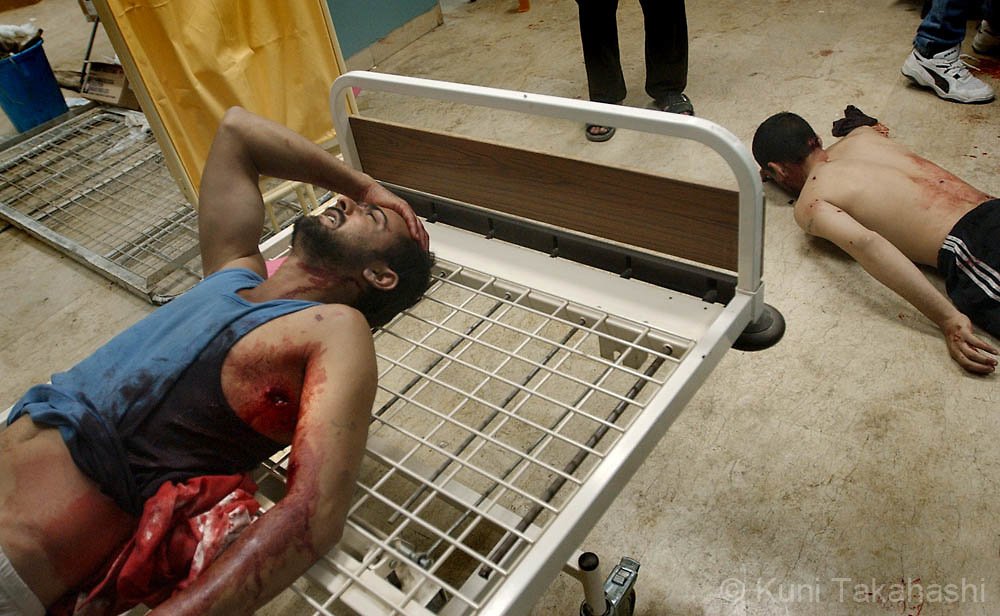 (4/12/03-Iraq, )  Iraqi men who were shot during the conflict with US are carried in emergency room at Shaheed Adnan Hospital in downtown Baghdad. Staff Photo by Kuni Takahashi.  Saved in ).
