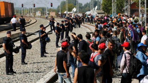 Police form a line in front of refugees at the railway station in Tovarnik, Croatia.