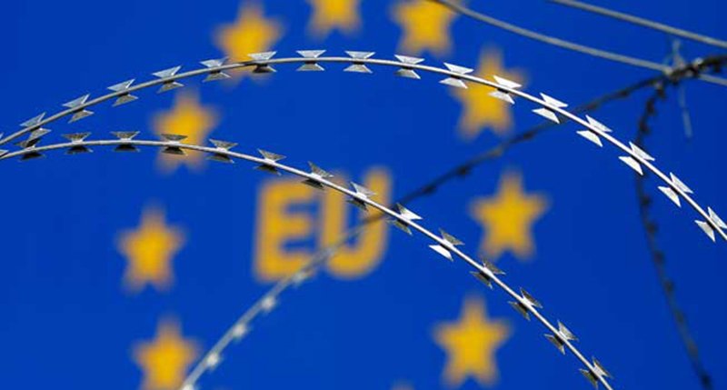 Razor wire is seen in front of an EU sign during a protest against barbed wire fences along the border crossing between Slovenia and Croatia in Brezovica pri Gradinu, Slovenia December 19, 2015. REUTERS/Srdjan Zivulovic