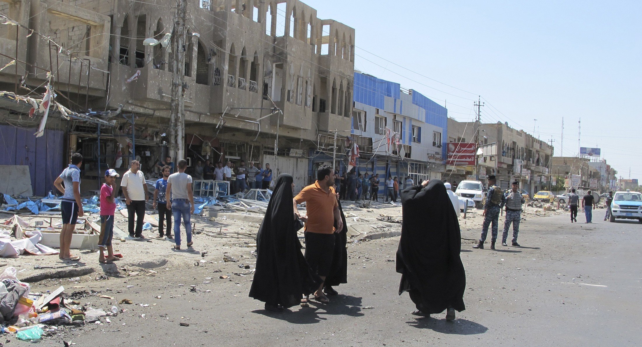 Residents gather at the scene of a car bomb attack in Baghdad July 19, 2014. A series of car bombs struck Baghdad on Saturday, killing 22 people, police and medics said. Car bombs exploded in three mainly Shi'ite districts, killing 15 people, the sources said, hours after a suicide car bombing killed seven people in another area of the capital. REUTERS/Ahmed Malik (IRAQ - Tags: CIVIL UNREST)
