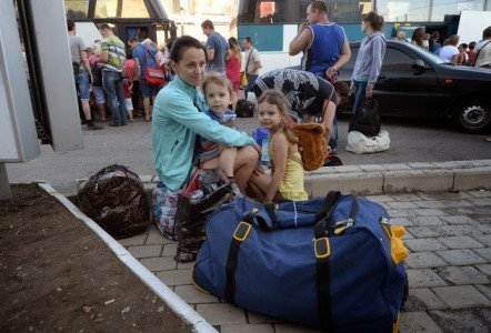 Ukrainian women an her little girls waiting to cross Russia