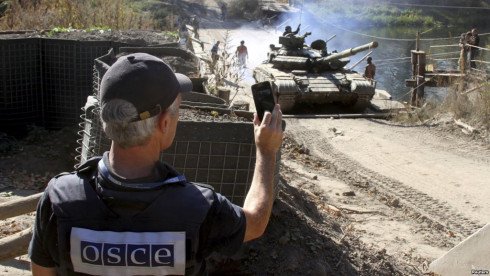A member of the OSCE monitors the withdrawal of tanks of the Ukrainian armed forces near the village of Nyzhnje in the Luhansk region on October 5
