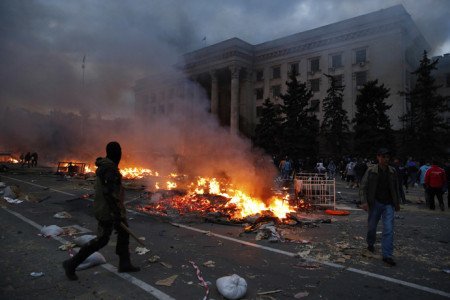 A protester walks past a burning pro-Russian tent camp near the trade union building in Odessa May 2, 2014. At least 38 people were killed in a fire on Friday in the trade union building in the centre of Ukraine's southern port city of Odessa, regional police said. REUTERS/Yevgeny Volokin