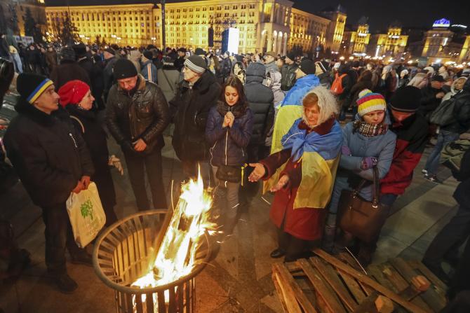 People warm themselves during an anti-government rally in central Kiev, Ukraine, Feb. 20, 2016. Photo: Reuters/Gleb Garanich