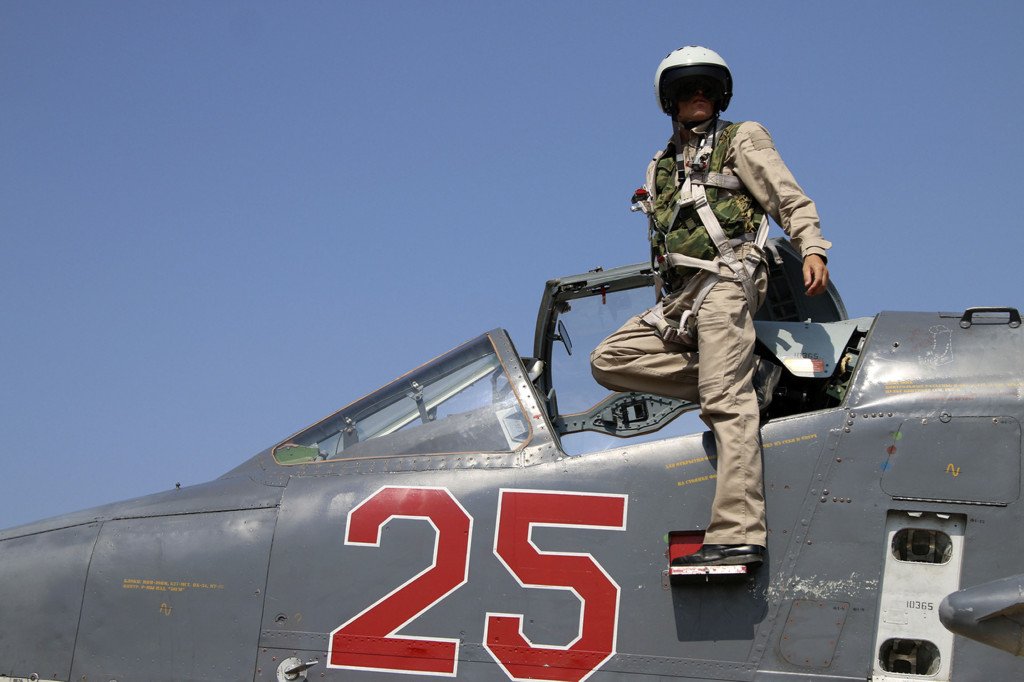 In this photo taken on Saturday, Oct. 3, 2015, Russian army pilot poses at a cockpit of SU-25M jet fighter at Hmeimim airbase in Syria. Russia has insisted that the airstrikes that began Wednesday are targeting the Islamic State group and al-Qaida's Syrian affiliates, but at least some of the strikes appear to have hit Western-backed rebel factions.(AP Photo/Alexander Kots, Komsomolskaya Pravda, Photo via AP)