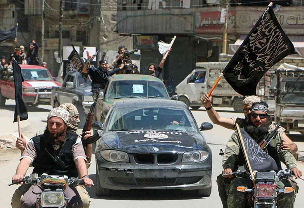 Fighters from Al-Qaeda's Syrian affiliate Al-Nusra Front drive in the northern Syrian city of Aleppo flying Islamist flags as they head to a frontline, on May 26, 2015. Once Syria's economic powerhouse, Aleppo has been divided between government control in the city's west and rebel control in the east since shortly after fighting there began in mid-2012. AFP PHOTO / AMC / FADI AL-HALABI / AFP PHOTO / AMC / Fadi al-Halabi