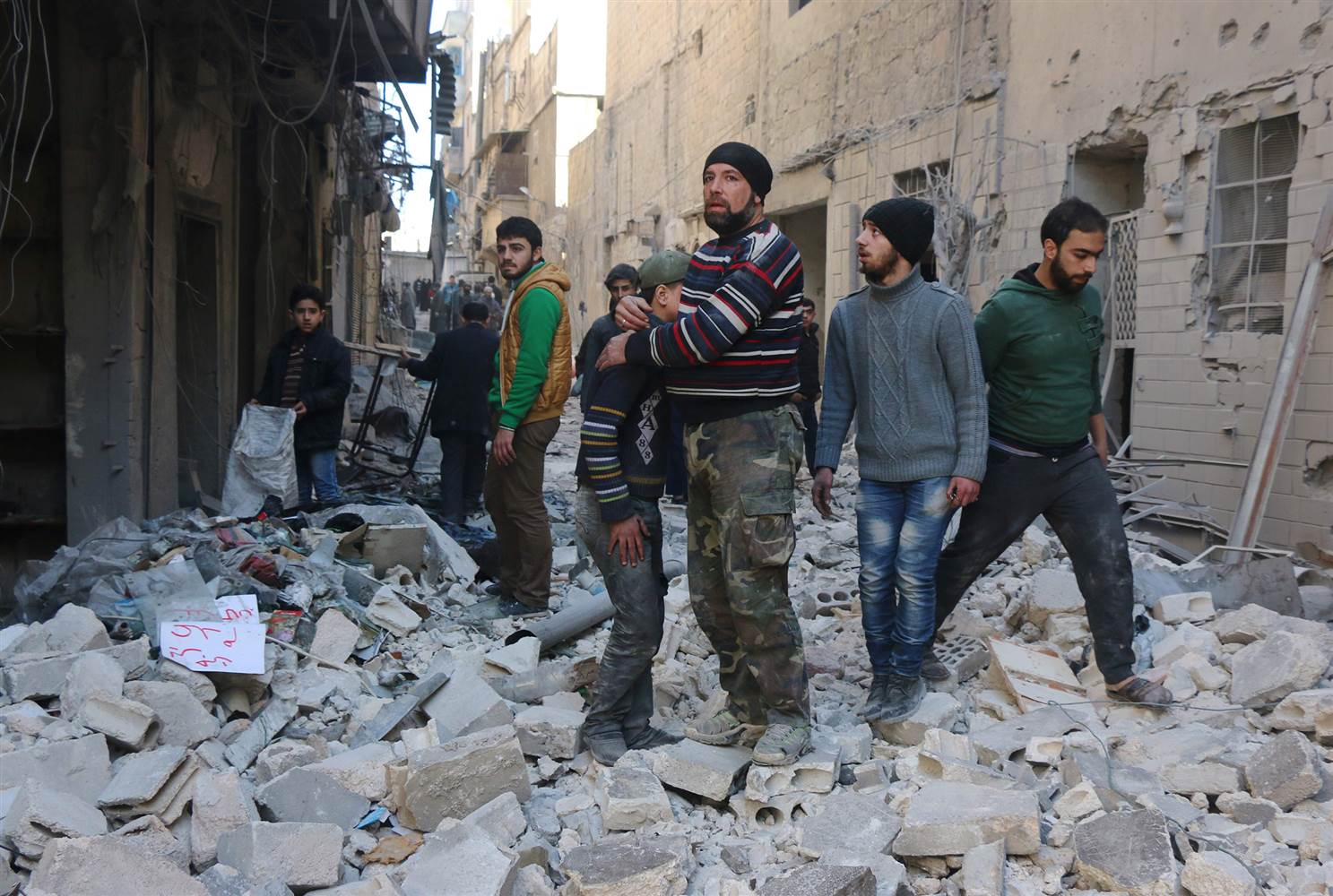 A Syrian man comforts a boy amid the rubble of buildings following a reported air strike on the rebel-held neighborhood of al-Kalasa in Aleppo on Thursday. / AFP / THAER MOHAMMEDTHAER MOHAMMED/AFP/Getty