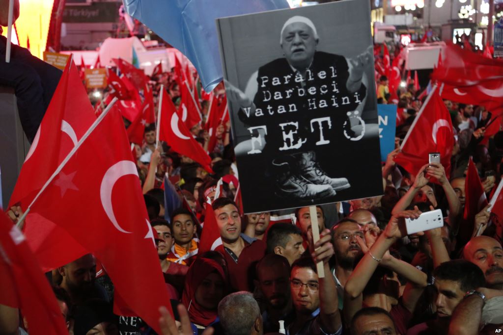 Supporters of Turkish President Recep Tayyip Erdogan wave their national flags and hold a portrait of Fethullah Gulen, a U.S.-based Muslim cleric, with Turkish words that read: "the Coup nation traitor, FETO" (Feto is the nickname of Fethullah Gulen), du