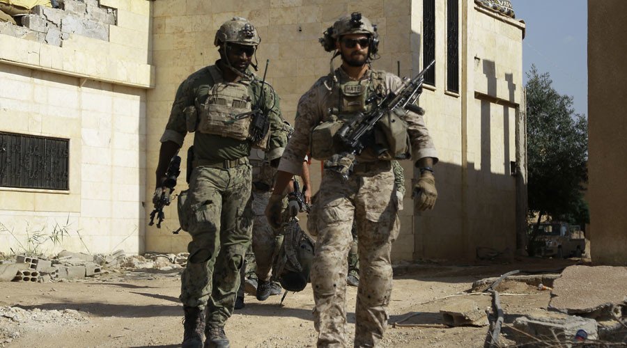 Armed men in uniform identified by Syrian Democratic forces as US special operations forces walk in the village of Fatisah in the northern Syrian province of Raqa on May 25, 2016. © Delil Souleiman / AFP