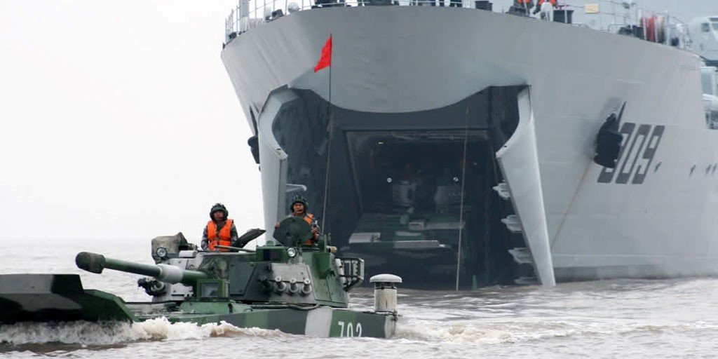 Type 072III LST landing ZBT05 amphibious assault vehicles via its bow ramp.