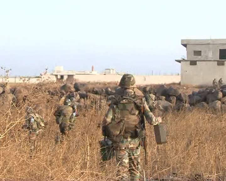 Soldiers from the 3rd Armored Division cross an open field after the Islamist rebels fled building ahead.