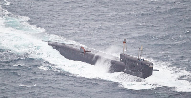 Although the articles say that this is a photo of the Russian attack sub accompanying the fleet, this could not possibly be true. This is in fact a Russian Delta Class SSBN, and not the attack submarine (SSN) which is actually accompanying the fleet.