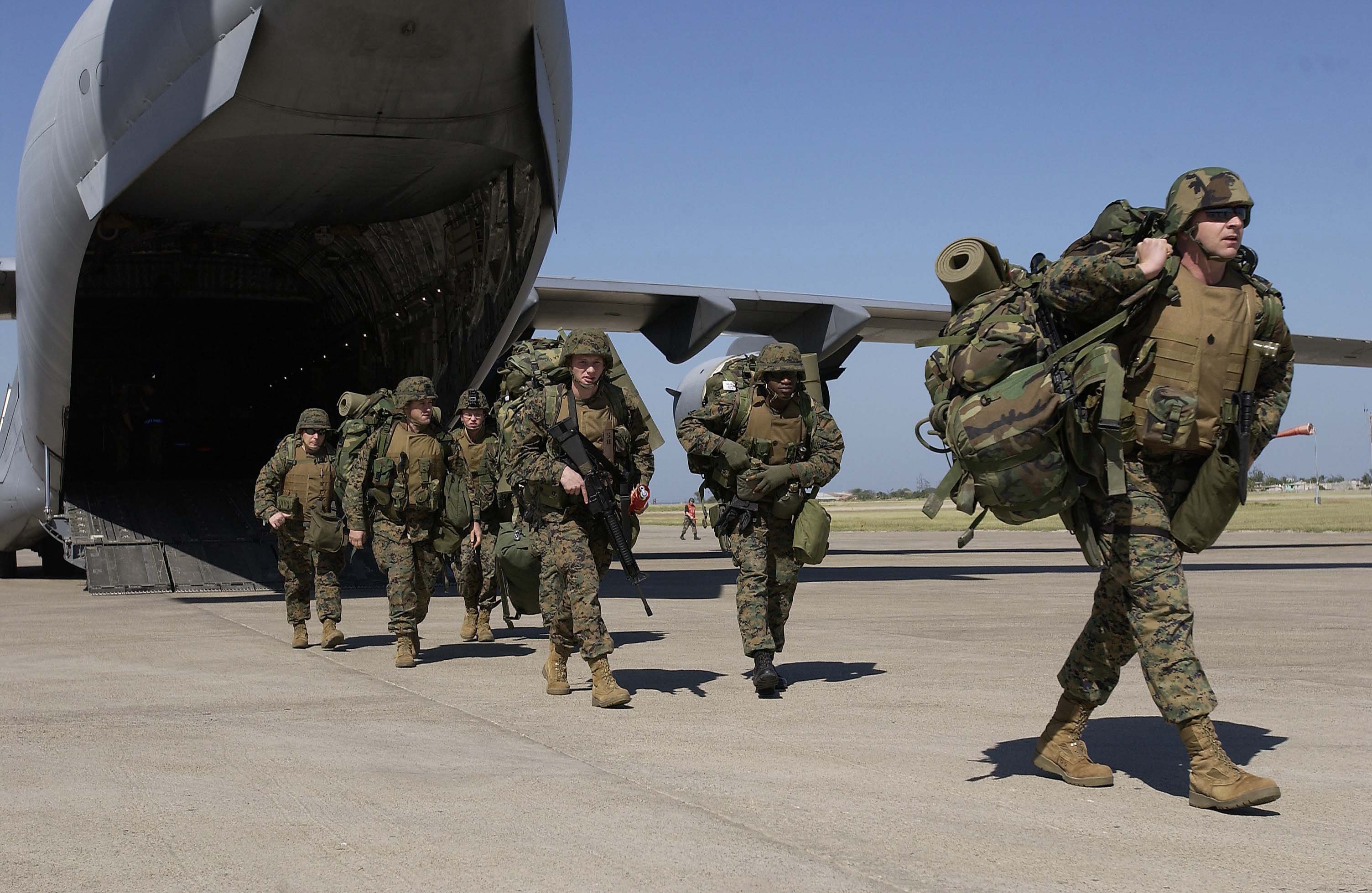 040304-F-2828D-065 U. S. Marines exit a C-17 Globemaster III at the Port-au-Prince airport in Haiti on March 3, 2004.  U.S. troops are deploying to Haiti at the request of the new President of Haiti to help promote the constitutional political process, to create conditions for the arrival of the U.N. multinational force, facilitate humanitarian assistance and secure key sites in the Haitian capital Port-au-Prince.  DoD photo by Tech. Sgt. Andy Dunaway, U.S. Air Force.  (Released)