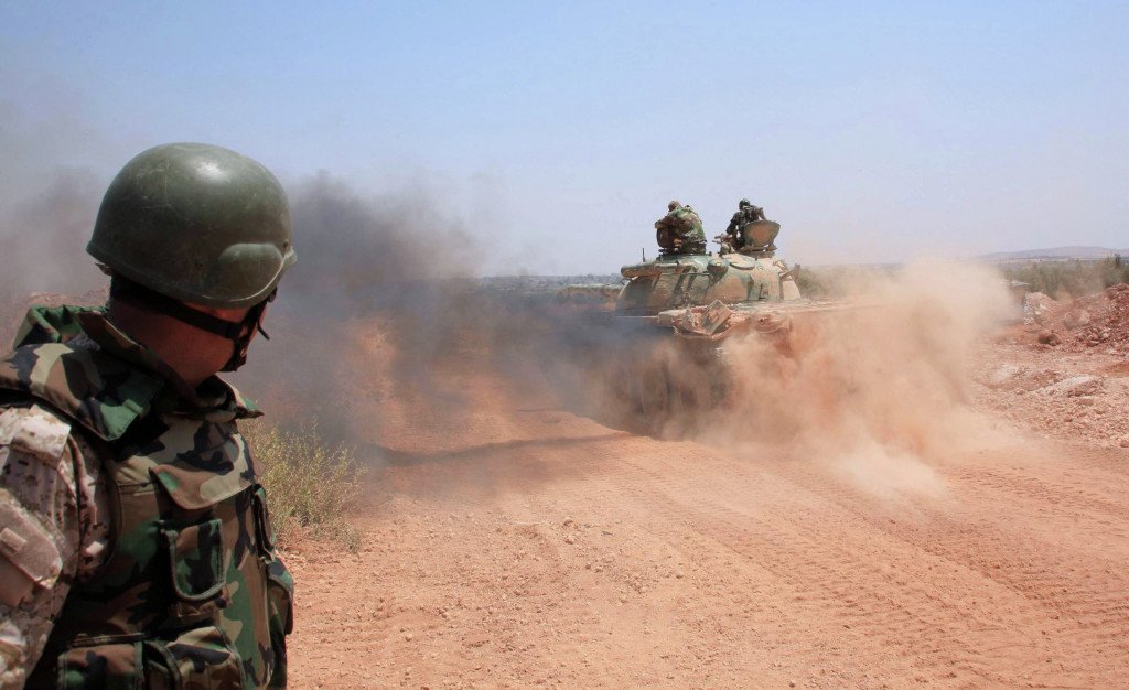 AFP 2016/ GEORGE OURFALIAN. Phono: Syrian government forces drive a tank on a road in the Maysar neighbourhood of the northern Syrian city of Aleppo on July 29, 2015