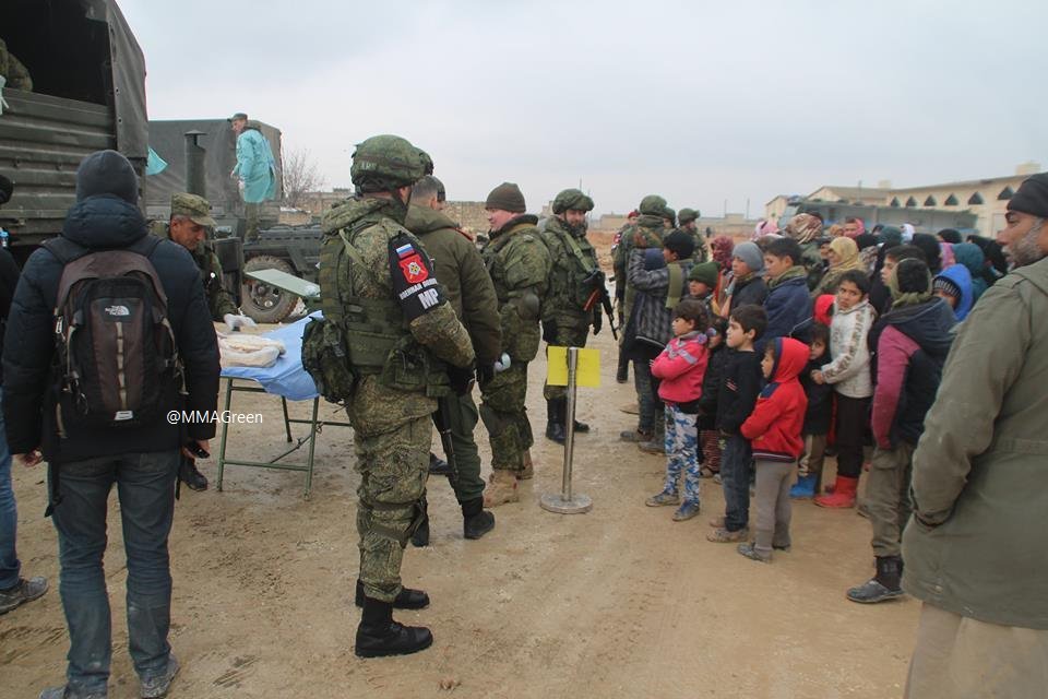 Russian military police servicemen distribute food to civilians in Aleppo city
