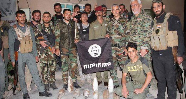 Iraqi troops with a captured ISIS flag
