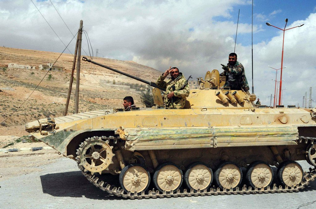 A Syrian army soldier flashes a 'V for victory' sign as his tank travels northeast of Damascus Getty Images