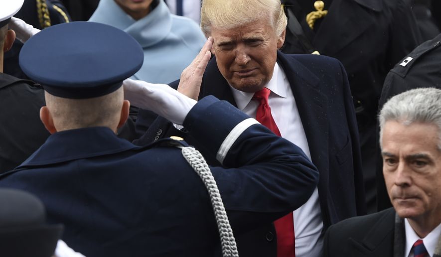 President Donald Trump salutes military personnel as he leaves Capitol Hill in Washington, Friday, Jan. 20, 2017, after taking the presidential oath. (Saul Loeb/Pool Photo via AP)