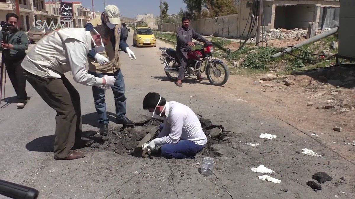 Photograph of men in Khan Sheikdoun in Syria, allegedly inside a crater where a sarin-gas bomb landed.