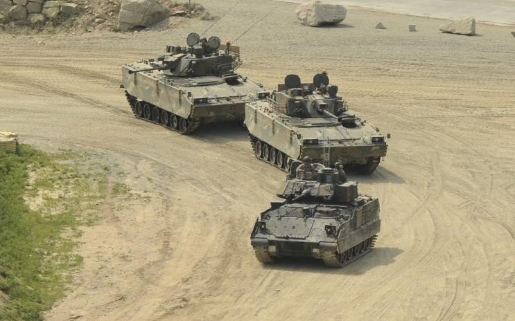 Two K21 IFVs follow an M3A2 Bradley at a military base in South Korea. Note the size comparison of the different vehicles.