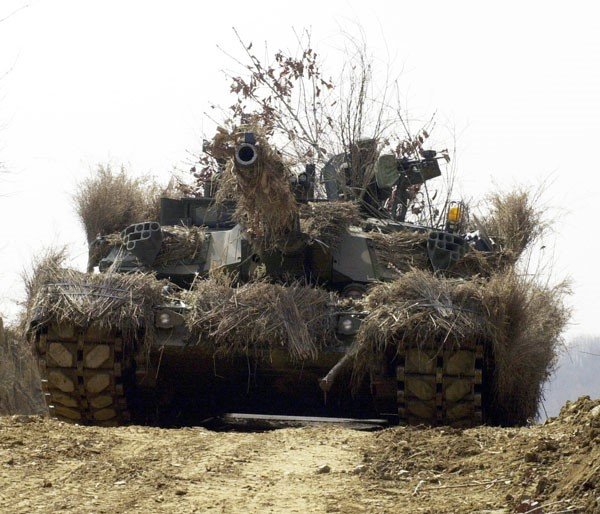 A heavily camouflaged K1A1/A2/E2 MBT during maneuvers close to the DMZ.